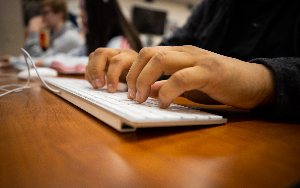  female students hands on keyboard on desk typing 